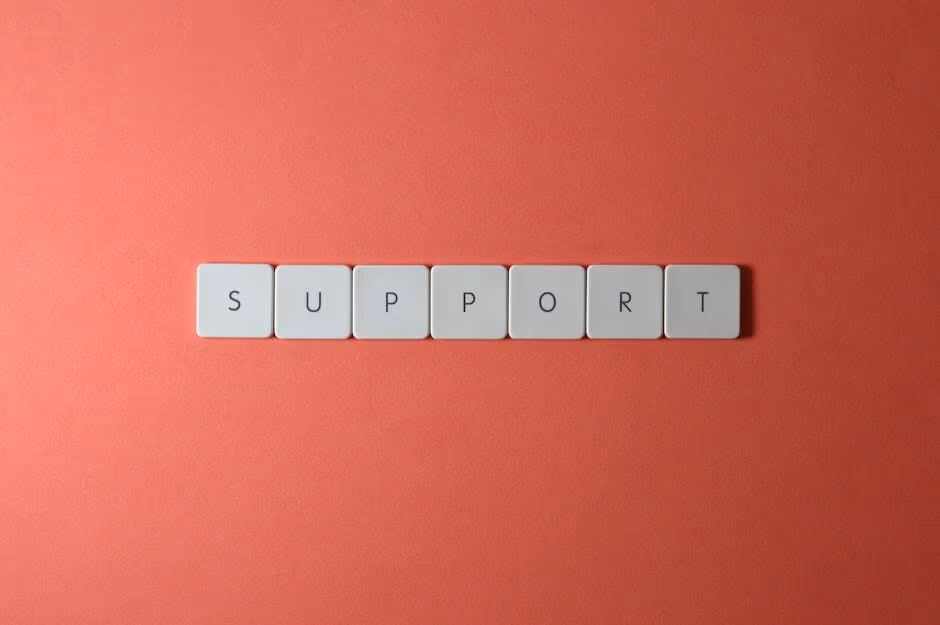Close-up of the word 'support' spelled with keyboard keys on a red background.